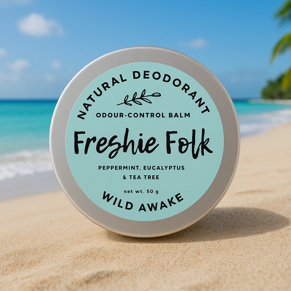 Natural deodorant balm container with 'Freshie Folk' branding on a beach.